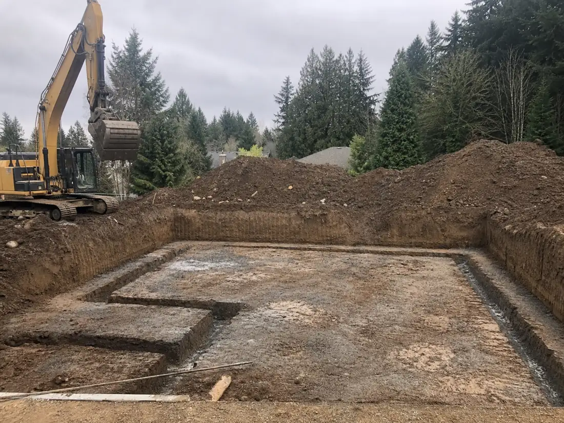 Foundation excavation with squared footing trenches and an excavator in Hillsboro, OR